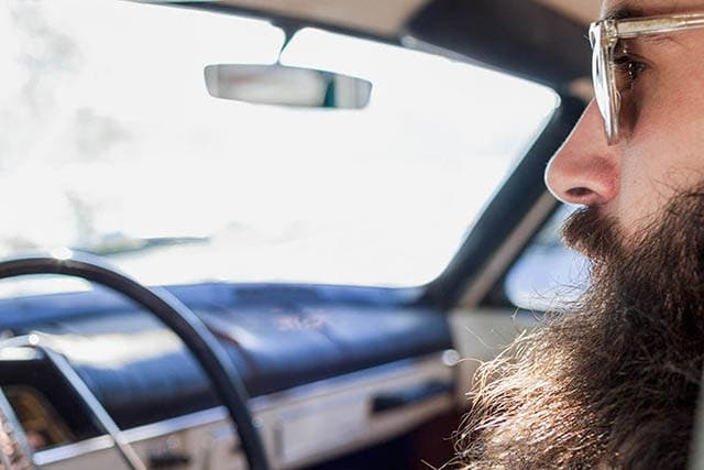 Mand kører i sin bil.