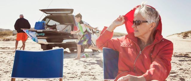 Familie på stranden. Bliv forsikret med re:member kreditkort.